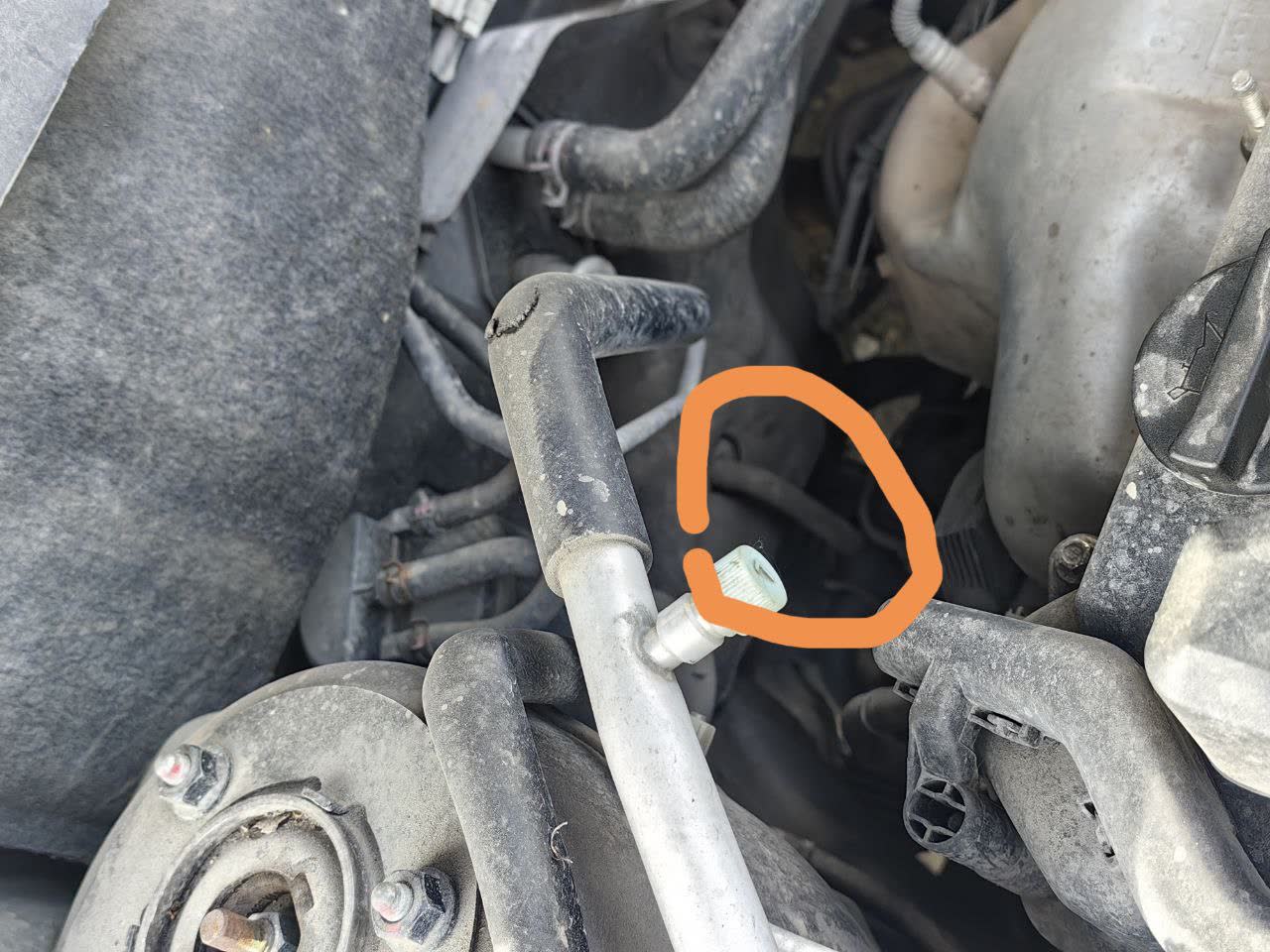 Photo showing the A/C drain tubing location with valve, referenced while diagnosing cabin water pooling