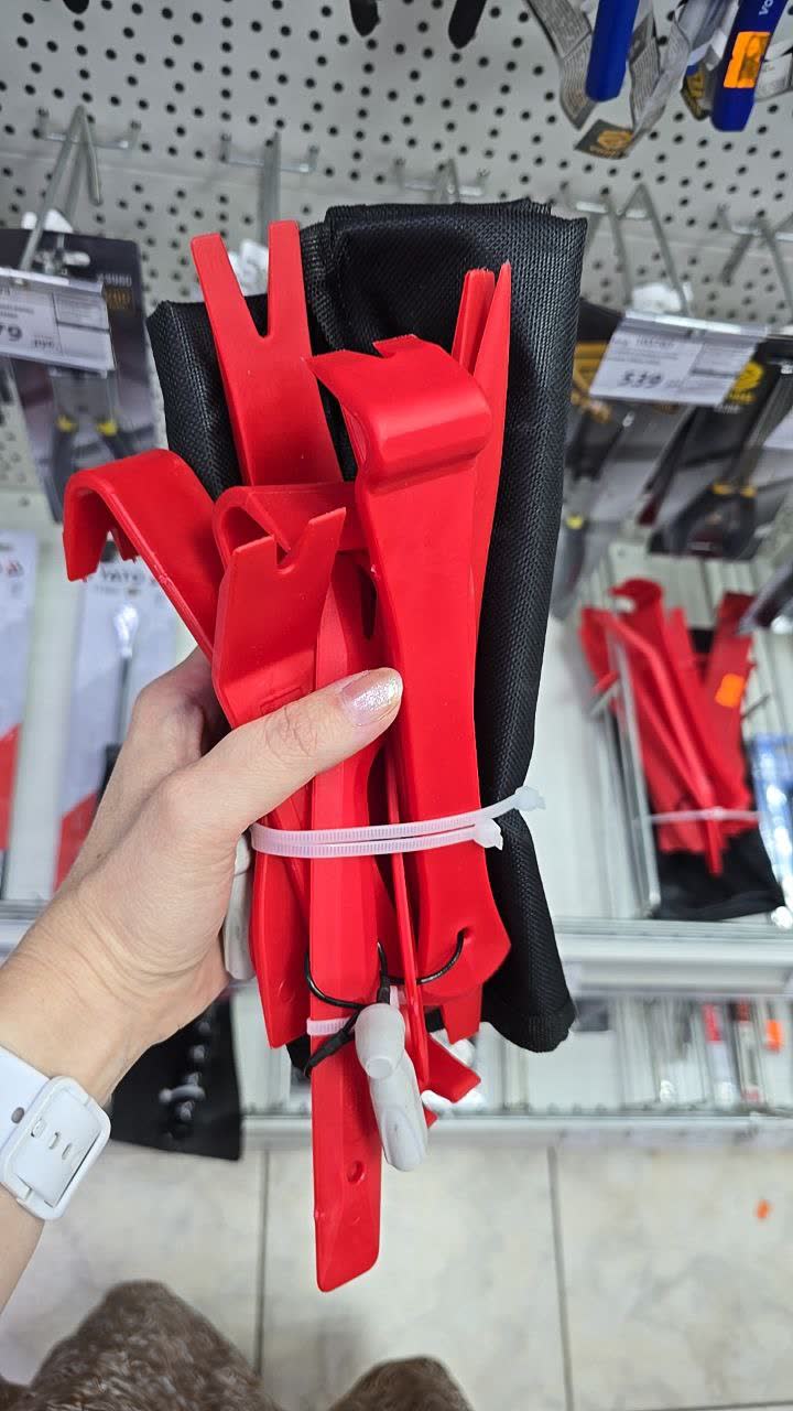 Photo of a red plastic trim tool set with multiple lever designs and a mesh carrying pouch