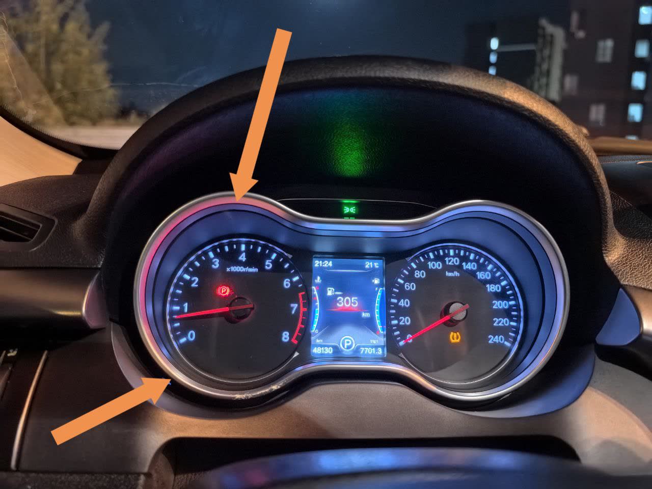 Dashboard photo showing plastic bezel frame around gauge cluster with arrows pointing to the squeak location