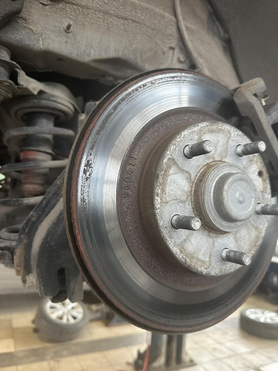 Rear brake disc showing only light, normal wear marks consistent with regular driving — not the damage pattern expected from a genuinely seized/locked caliper, contradicting the dealership's "clinched caliper" claim