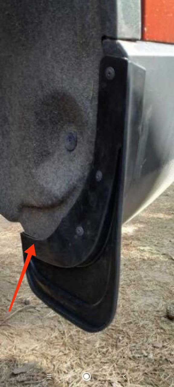 Properly fitting splash guard with a lower attachment bracket, indicated by a red arrow