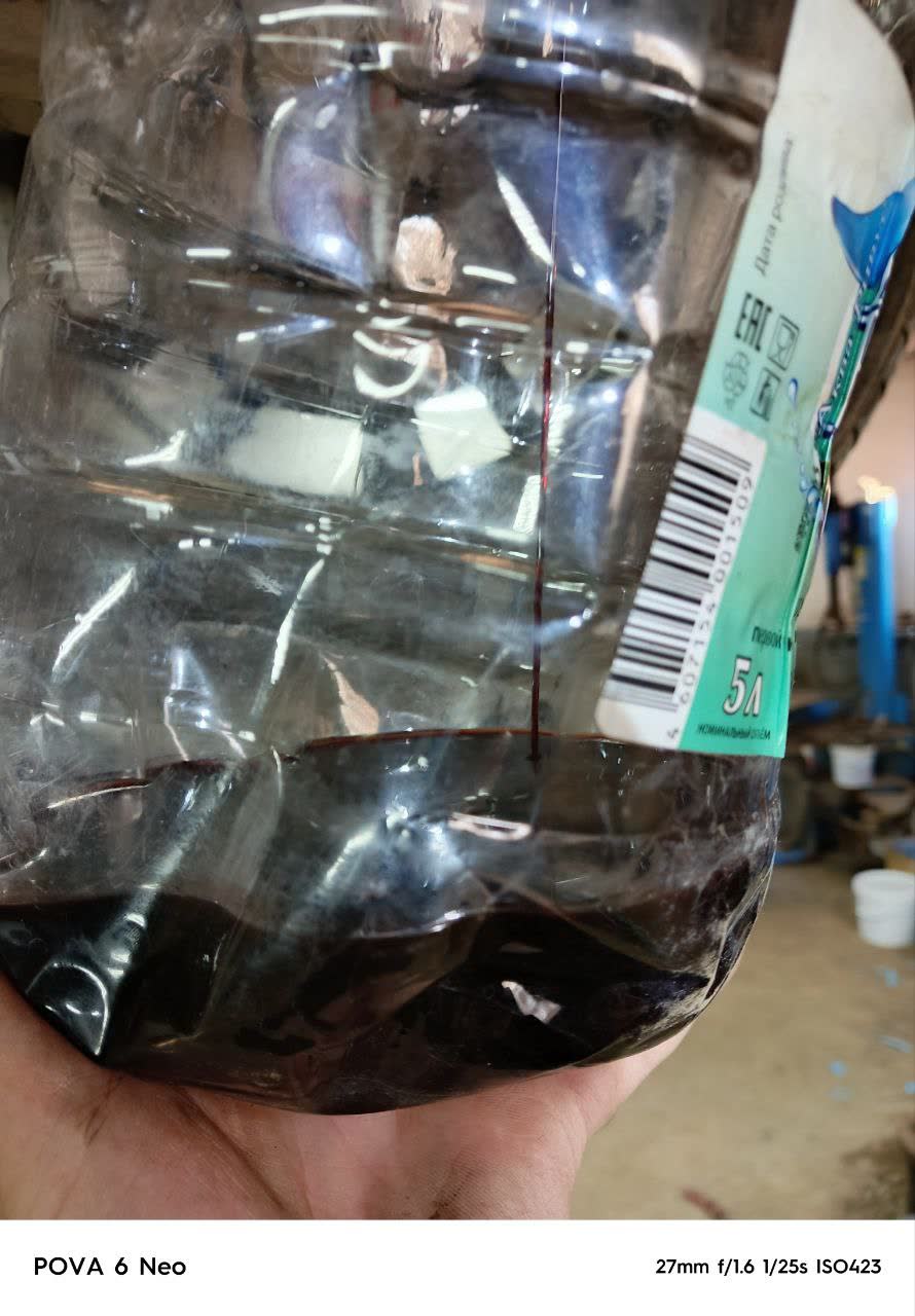 Transmission fluid being drained from the AKPP sump, approximately 2.5–3 L extracted
