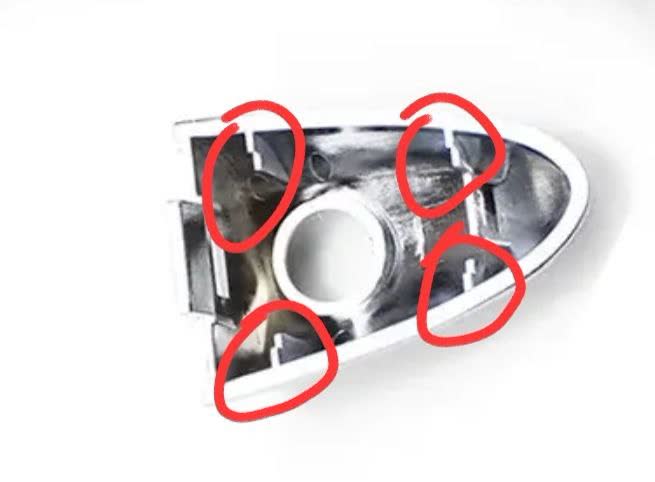 Door handle cover interior with red circles marking areas needing filing/sanding — adhesive contact points and lock-tab clearance zones