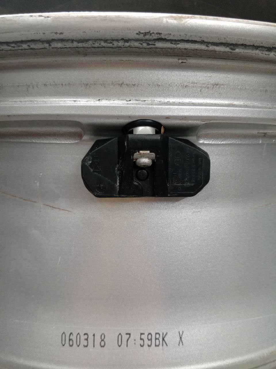 TPMS sensor with part number 5GA037973, mounted on a wheel