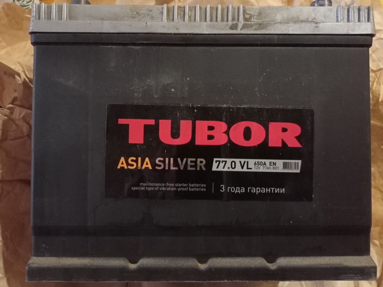 TUBOR ASIA SILVER 77.0 VL 650A EN battery label showing 12V-77Ah B01, 3-year warranty, maintenance-free