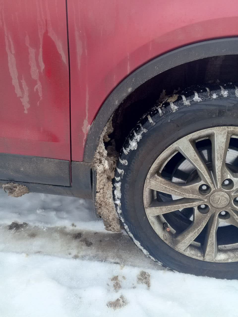 Ice/snow accumulation on vehicle exterior, demonstrating fuel-door access difficulty
