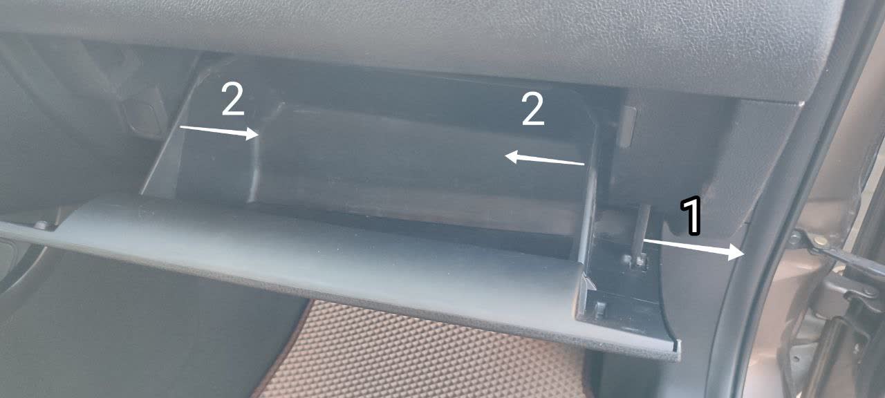 Glove box with numbered arrows indicating: point 1 = upper release button, points 2 = outward pull clips on both sides