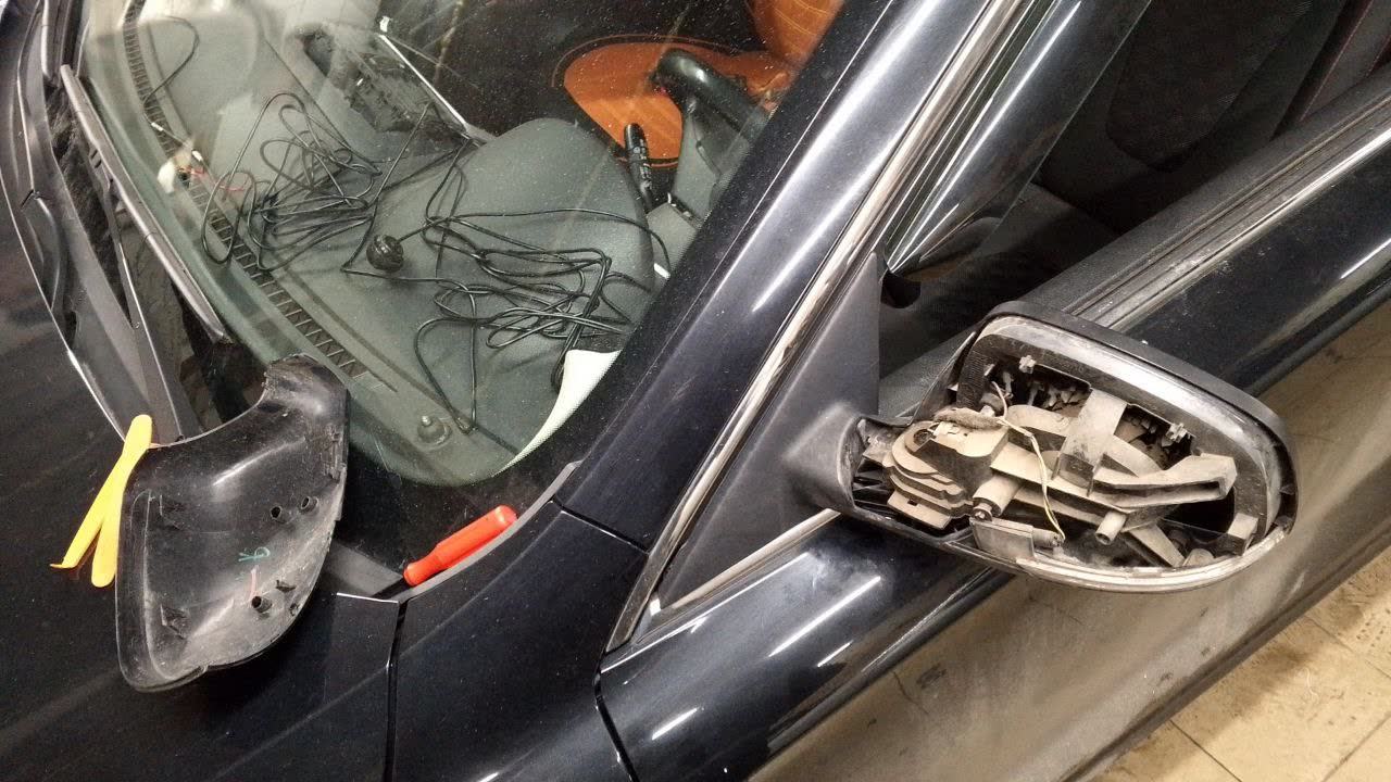 Mirror disassembly in progress, showing mirror element and housing separated