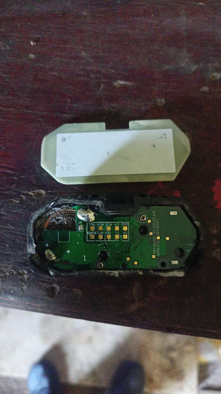 Disassembled TPMS sensor with plastic cap removed, showing internal PCB and component layout — demonstrates that sensors contain sealed electronics
