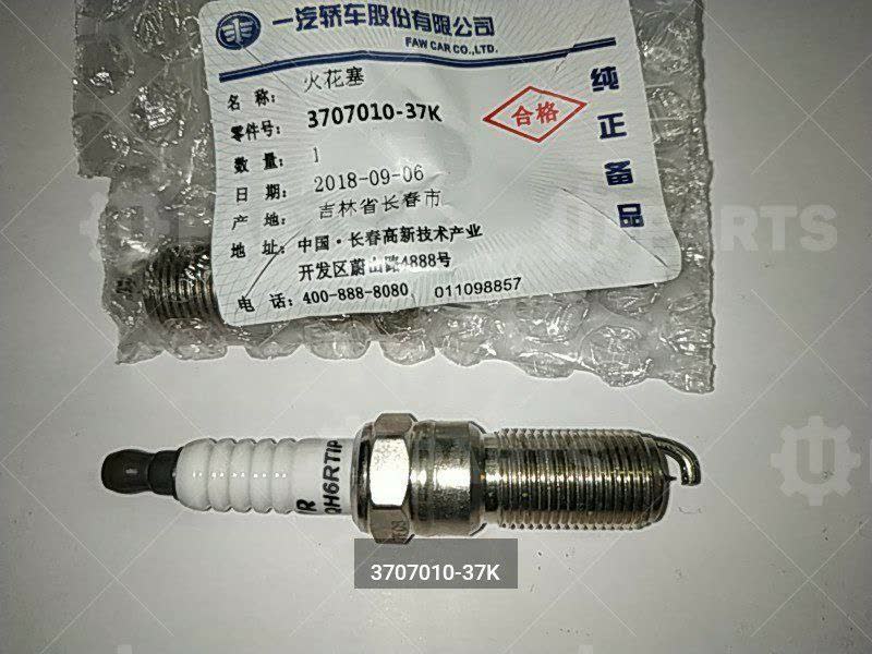 Close-up photo of the OEM spark plug electrode showing the iridium/platinum composite pad