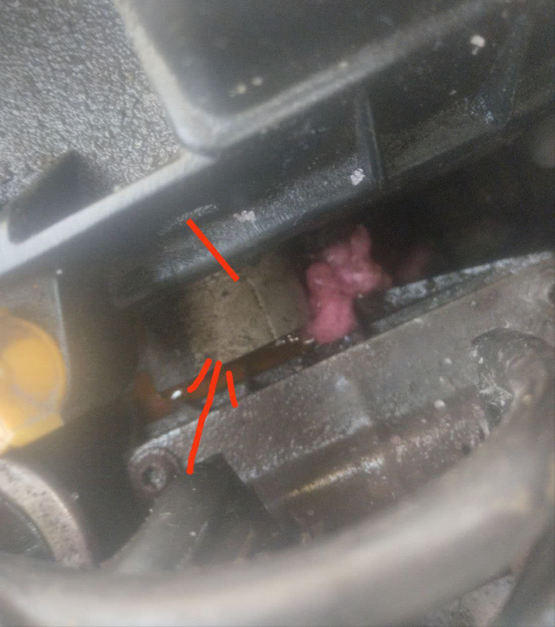 Photo of coolant leak location on the engine head near the temperature sensor, showing wet corrosion staining along the suspected weld seam