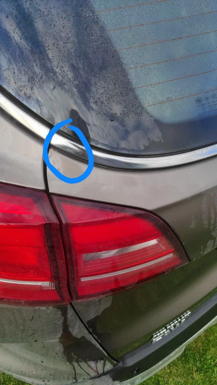 Photo showing rust and paint oxidation under chrome trim at the tailgate corner