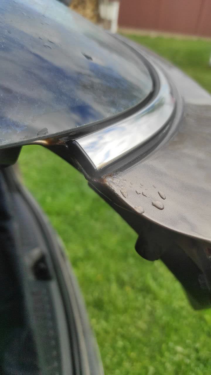Photo showing rust and paint oxidation under chrome trim at the tailgate corner