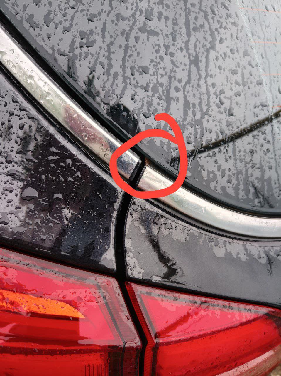 Comparison photo showing lighter paint discoloration (not full rust) at the same tailgate corner spot on a different car