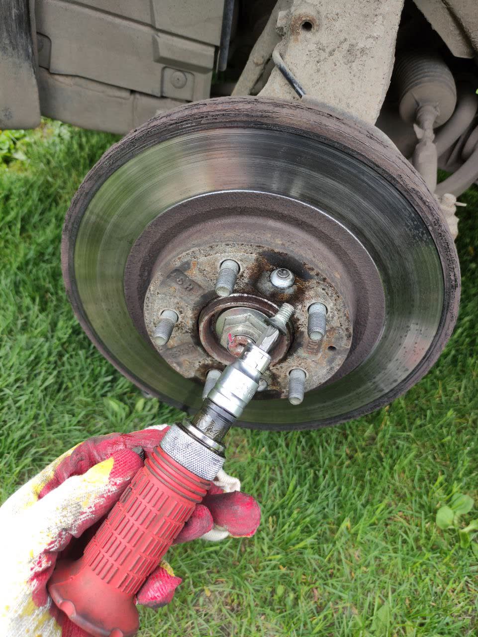 Photo showing the three small brake disc retaining screws before removal