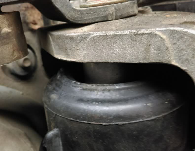 Close-up of the hydro-mount showing the rubber boot and metal insert, with the ~1cm gap indicator visible