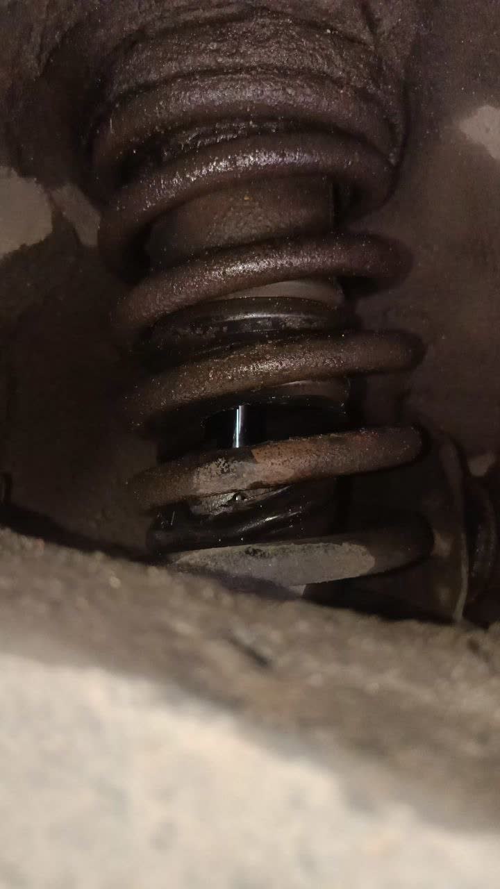 Torn shock-absorber protective boot with a hole and deteriorated rubber, allowing water into the spring/strut area
