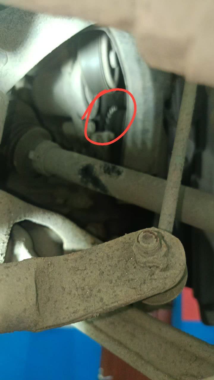 Photo of the engine bay showing the area around the engine mount with suspected oil seepage near the crankshaft seal location