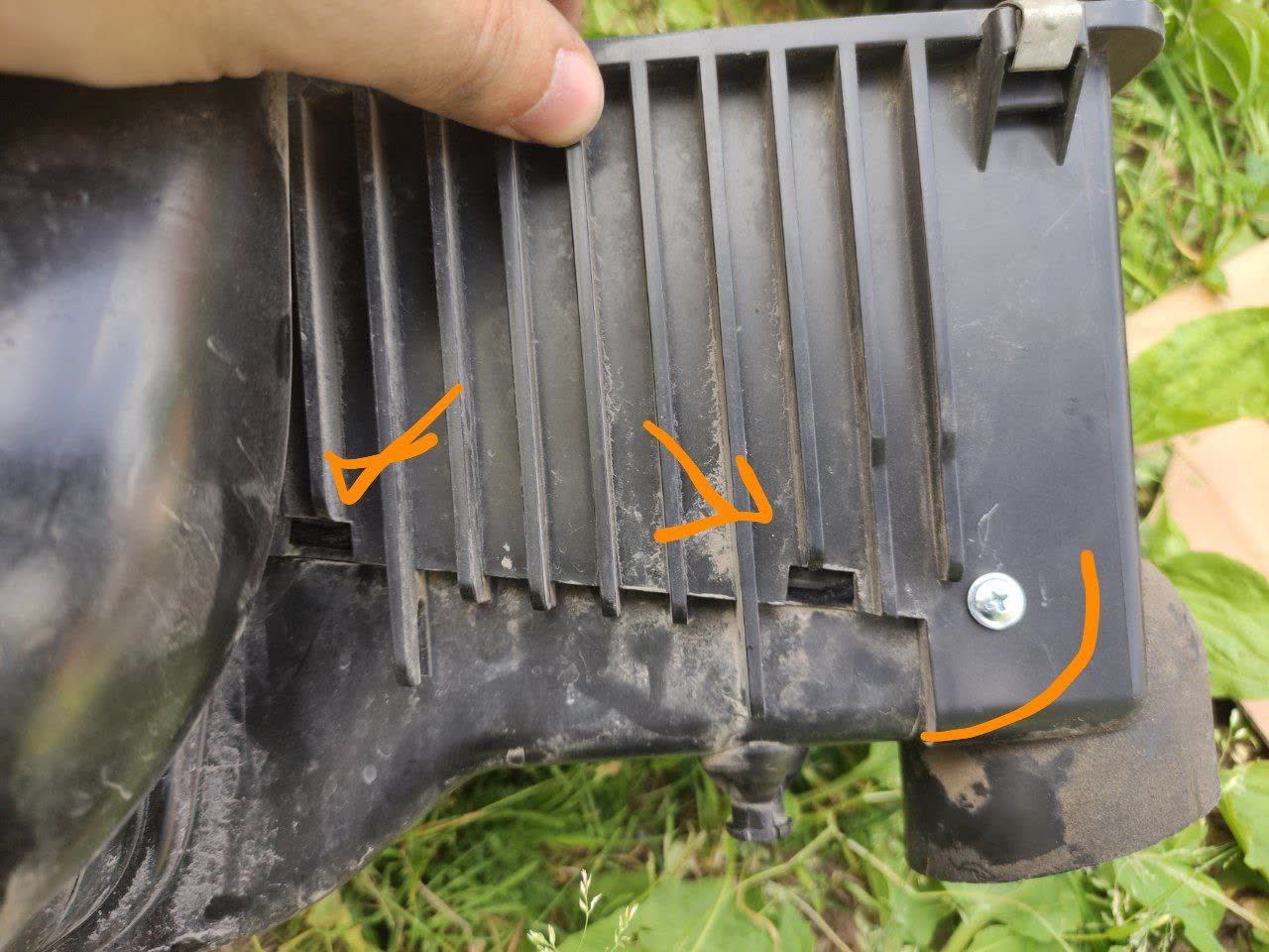 Photo of the plastic filter-resonator insert with loose/failed retention clip tabs marked
