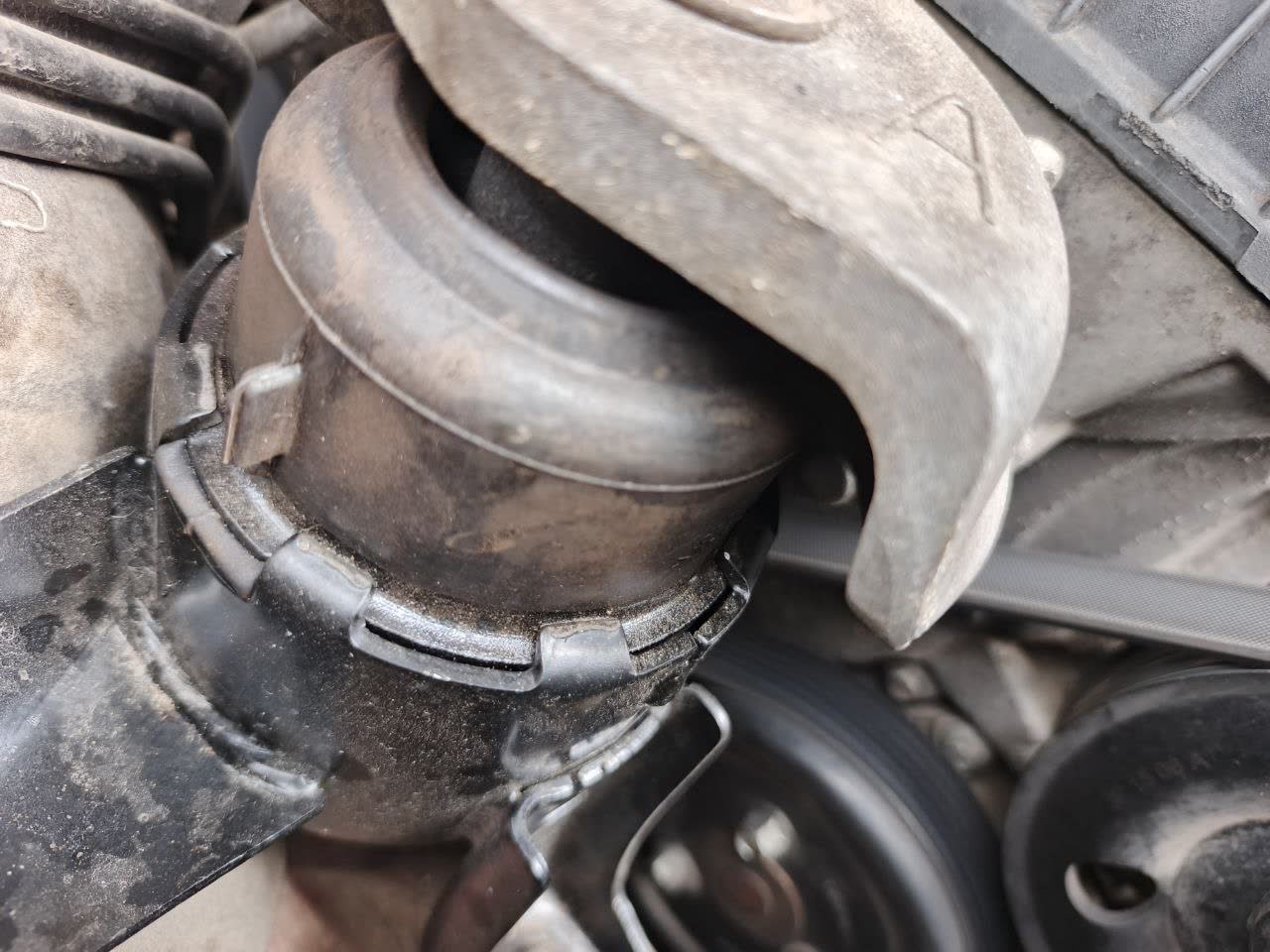 Hydraulic engine mount installation, visible as a fluid-filled mount with characteristic hemispherical shape