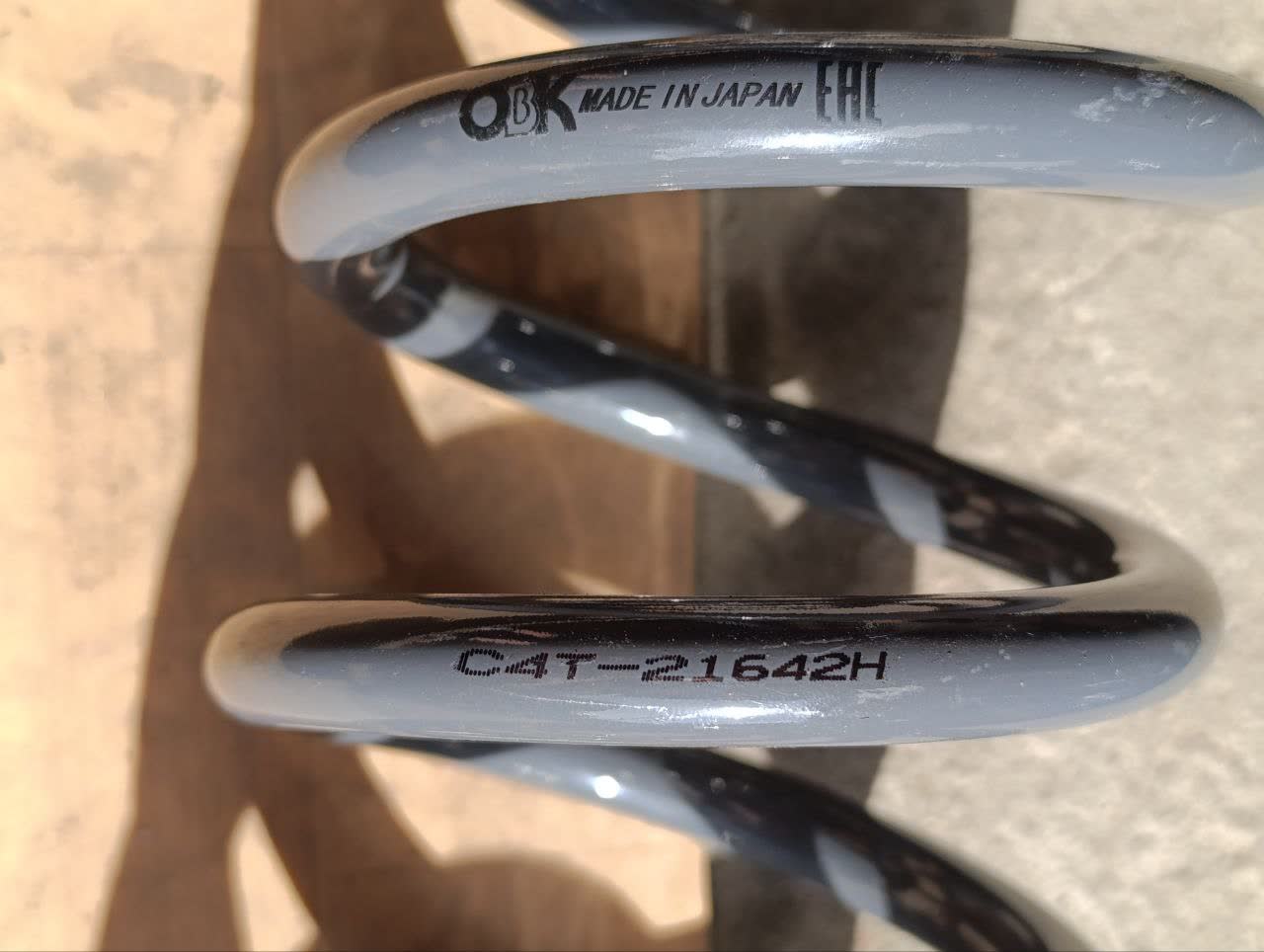 Installed Kia Sorento rear spring (CAT-21642H) showing fitment in the X80 lower spring cup