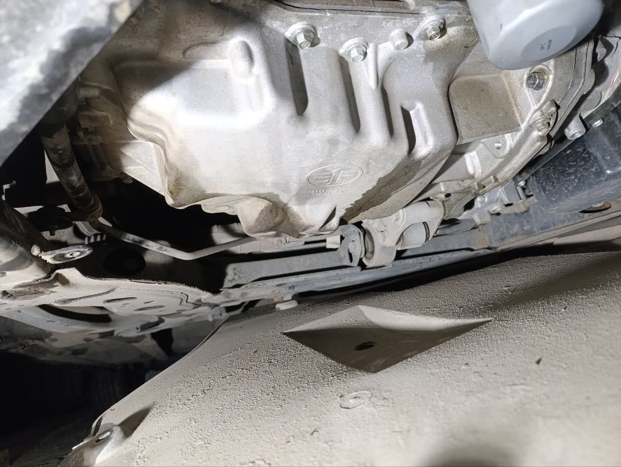 Photo showing oil pan wetness and suspected plug leak location
