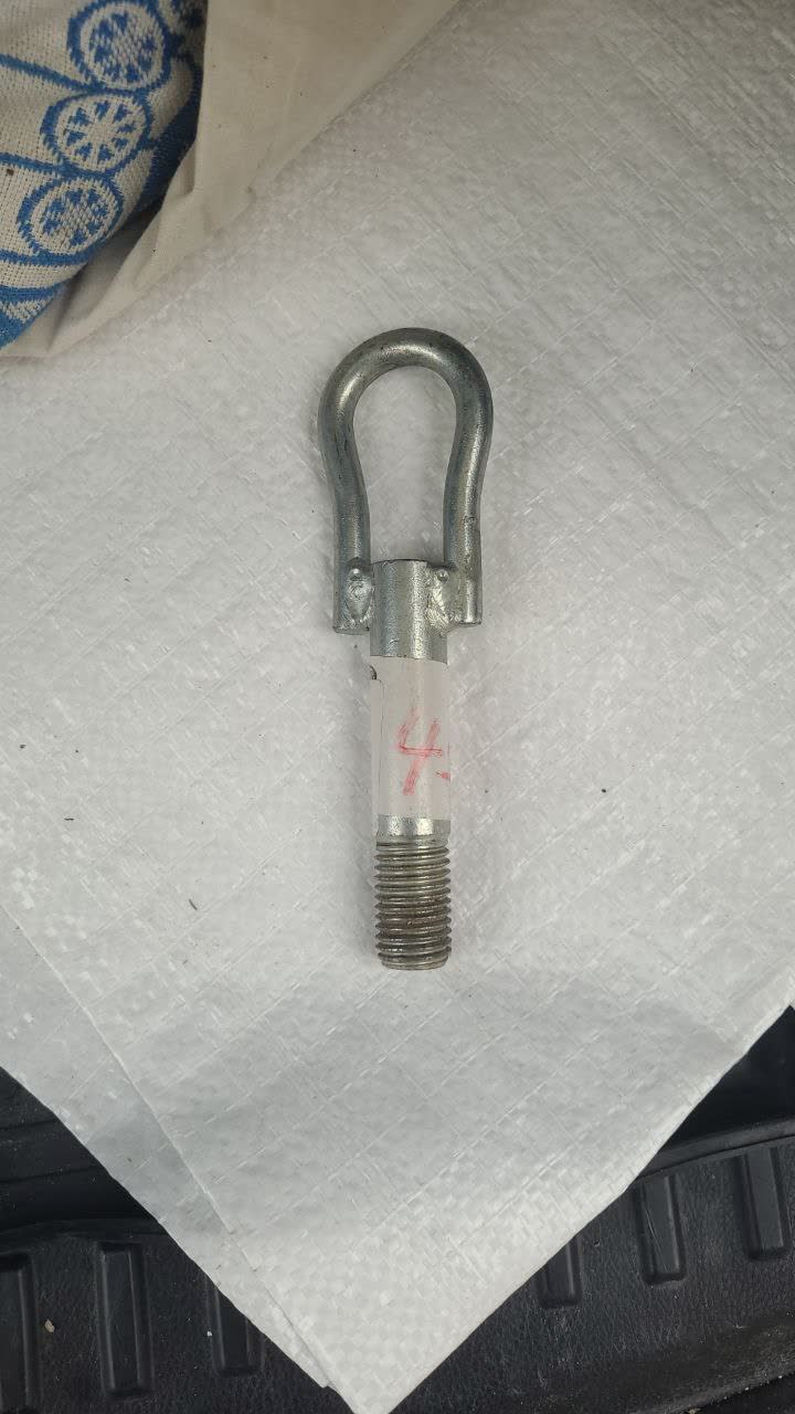 Towing hook photographed with calipers measuring thread pitch (~2mm visible)