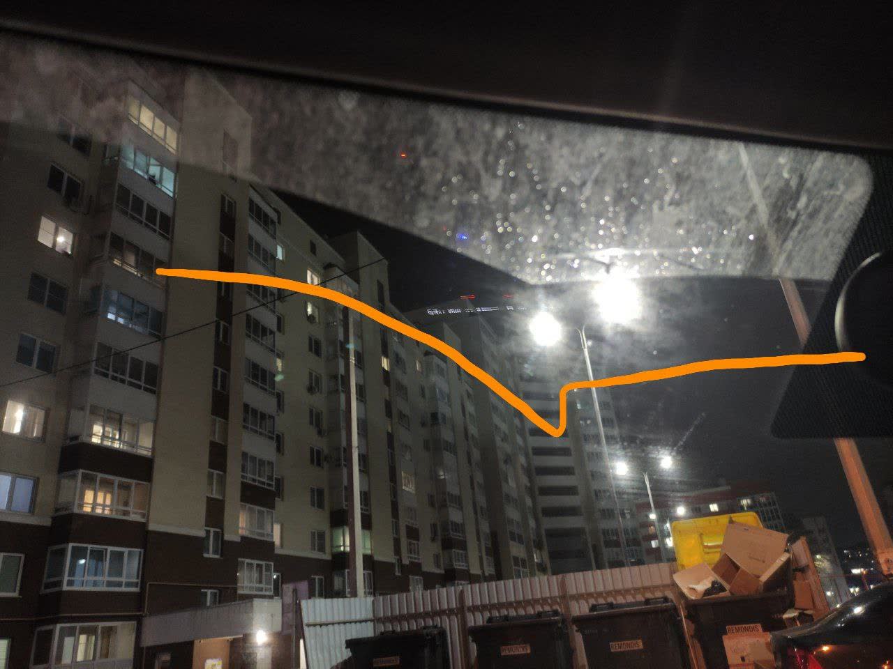 Photo showing the gap between the right wiper blade and windshield due to glass curvature (orange annotation)