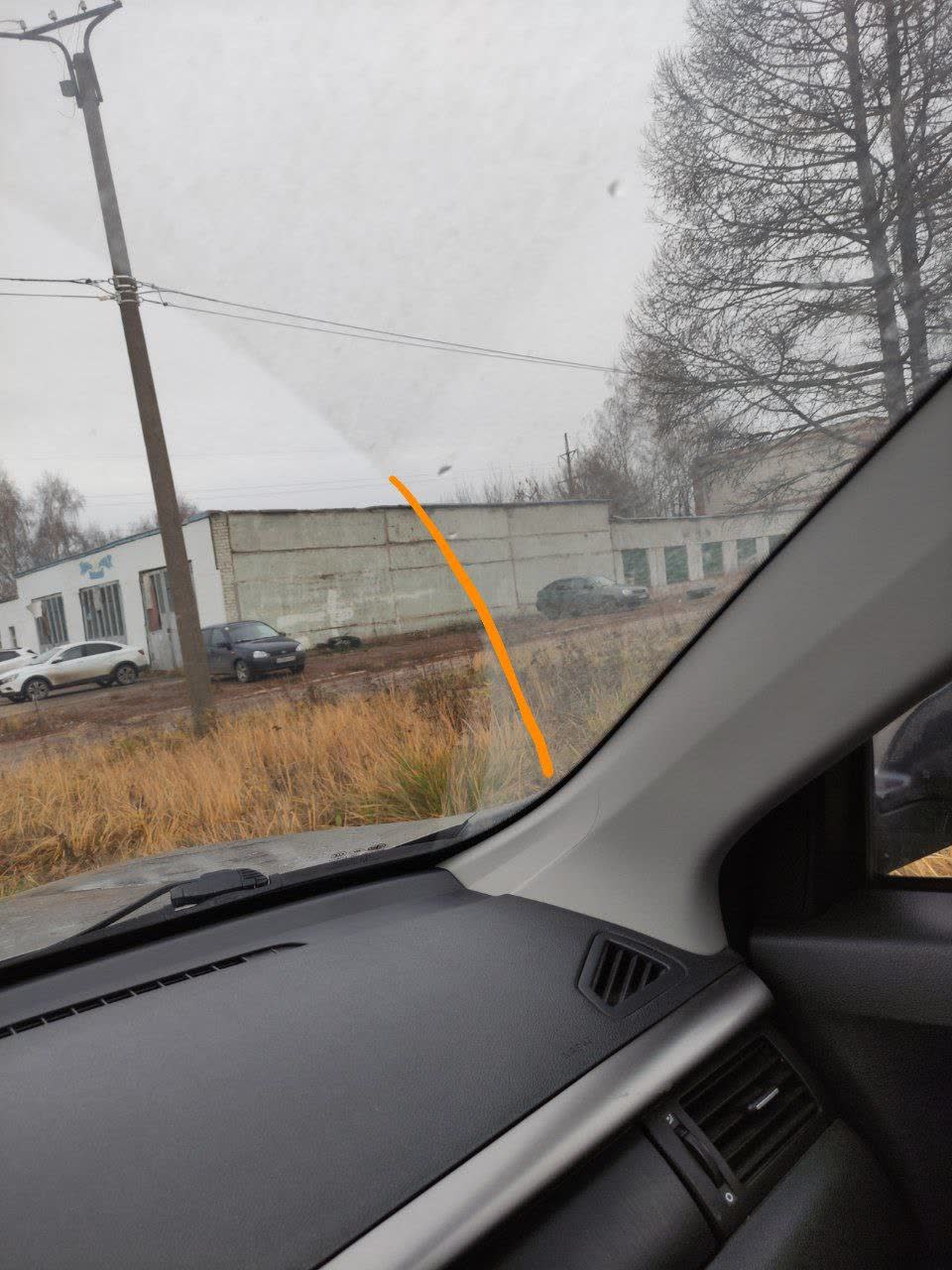 Photo showing the same right-side windshield curvature gap, marked with an orange line
