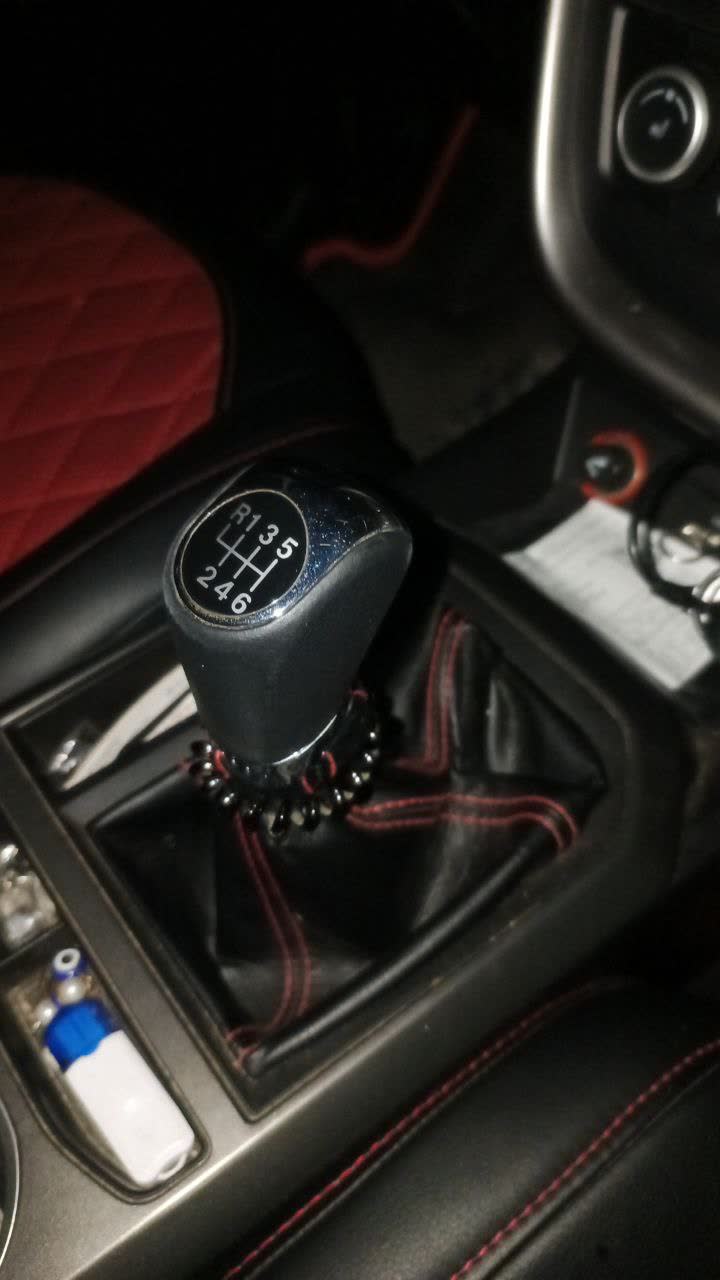 Photo showing replacement shift knob boot with red stitching, demonstrating proper fitment