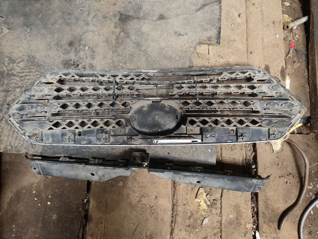 Disassembled grille showing clip attachment points at the bottom