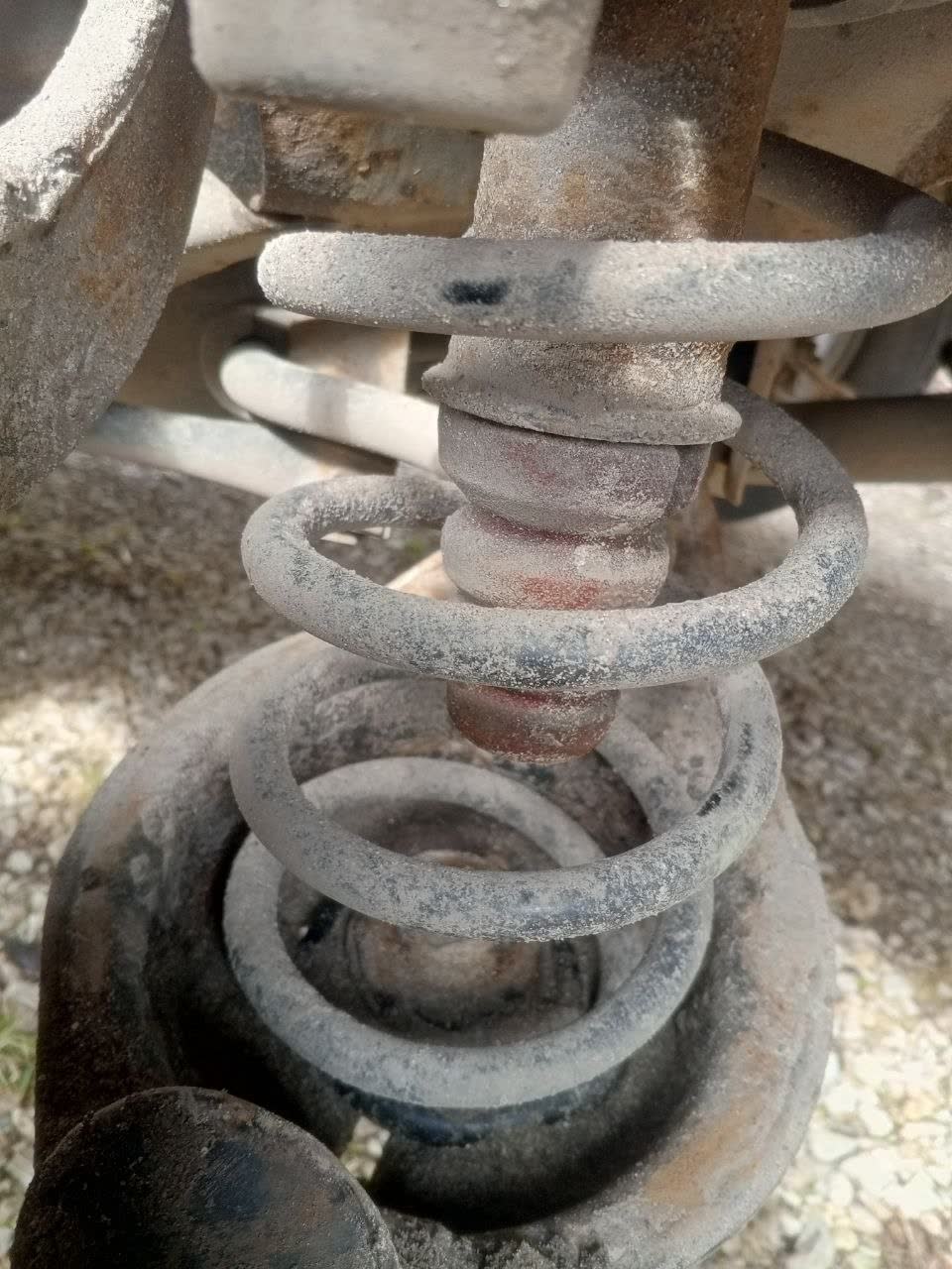 Coil spring with bump stop setup, showing the parts that get modified/removed for an air-spring install