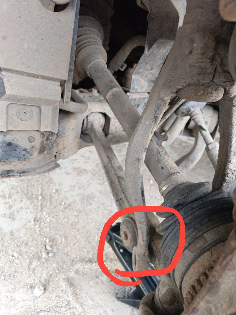 Front suspension with the spring expanded/released after the horizontal strut-to-lower-arm bolt was accidentally removed