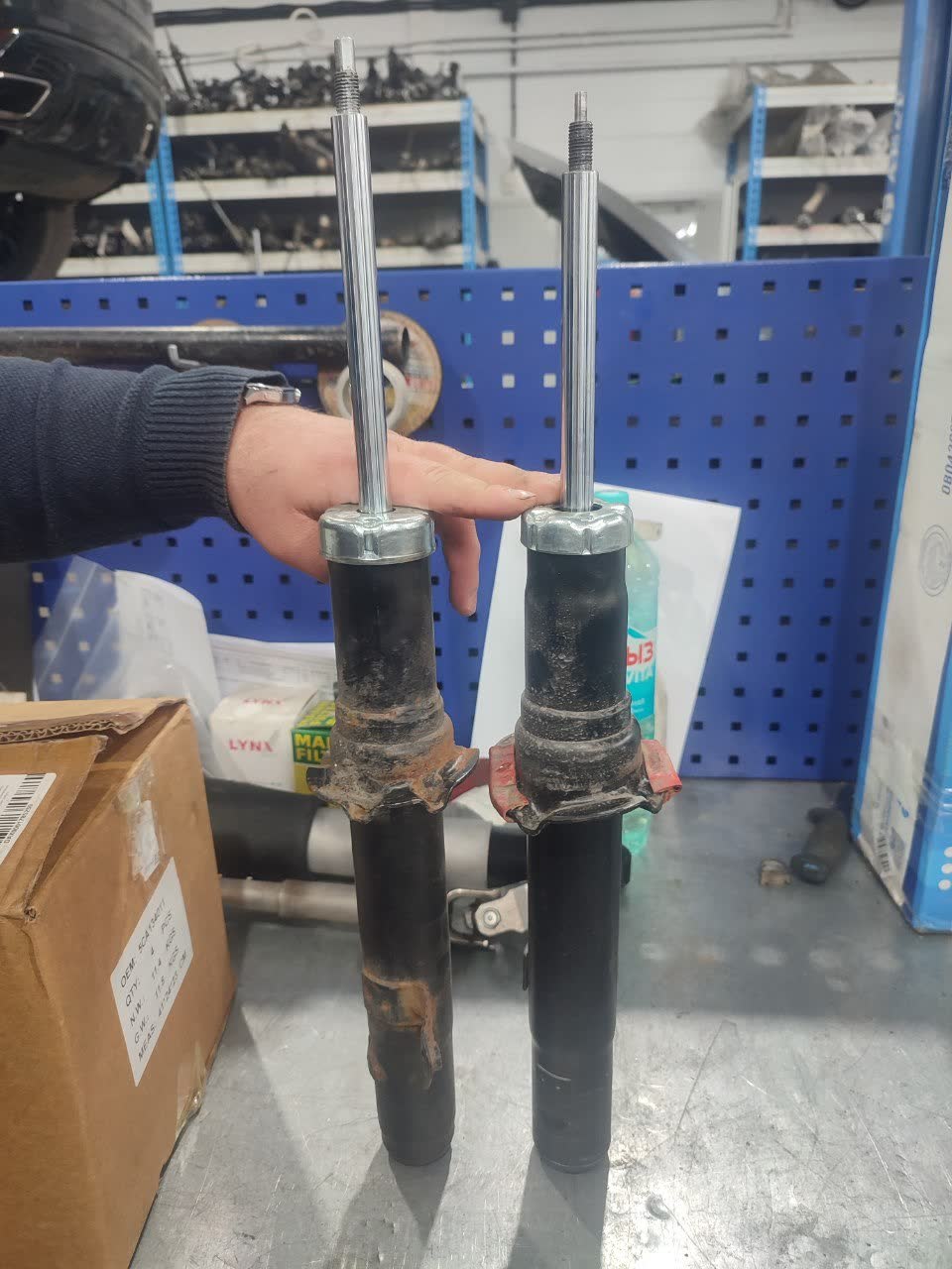 Side-by-side comparison of two shock absorber rods of different lengths (left taller than right), illustrating the GG-vs-GH strut height mismatch