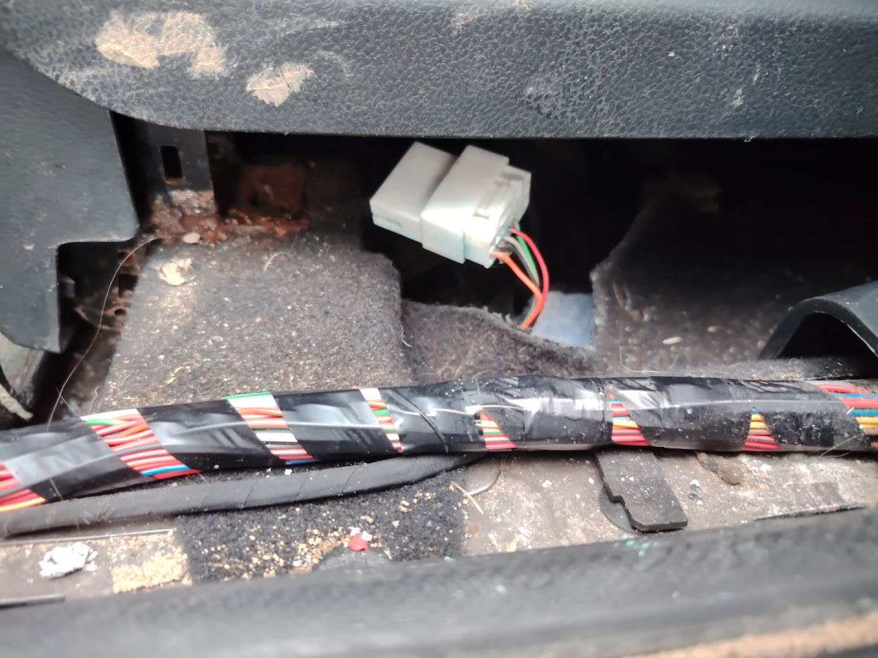 GLONASS module location under the driver's seat, with wiring harness and connectors visible