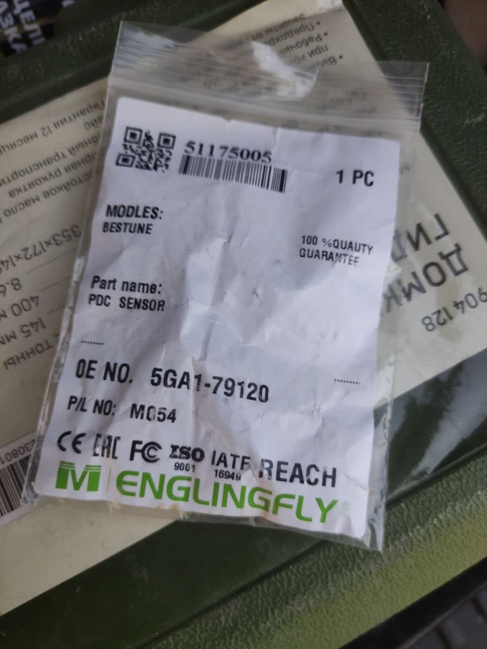 Cheap aftermarket parking-sensor packaging (thin plastic bag, Englingfly brand) indicating poor quality vs. proper sealed packaging