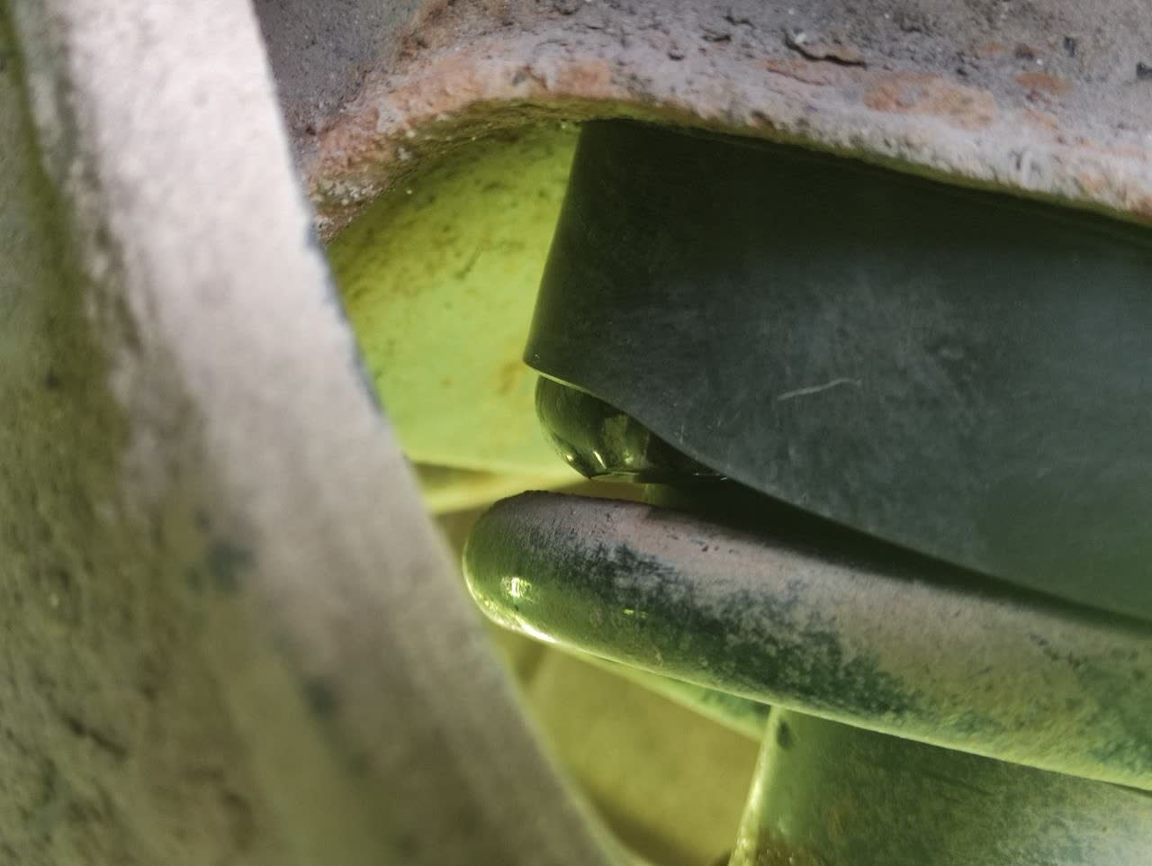 The diagonal-cut modification applied to the spring's upper coil edge