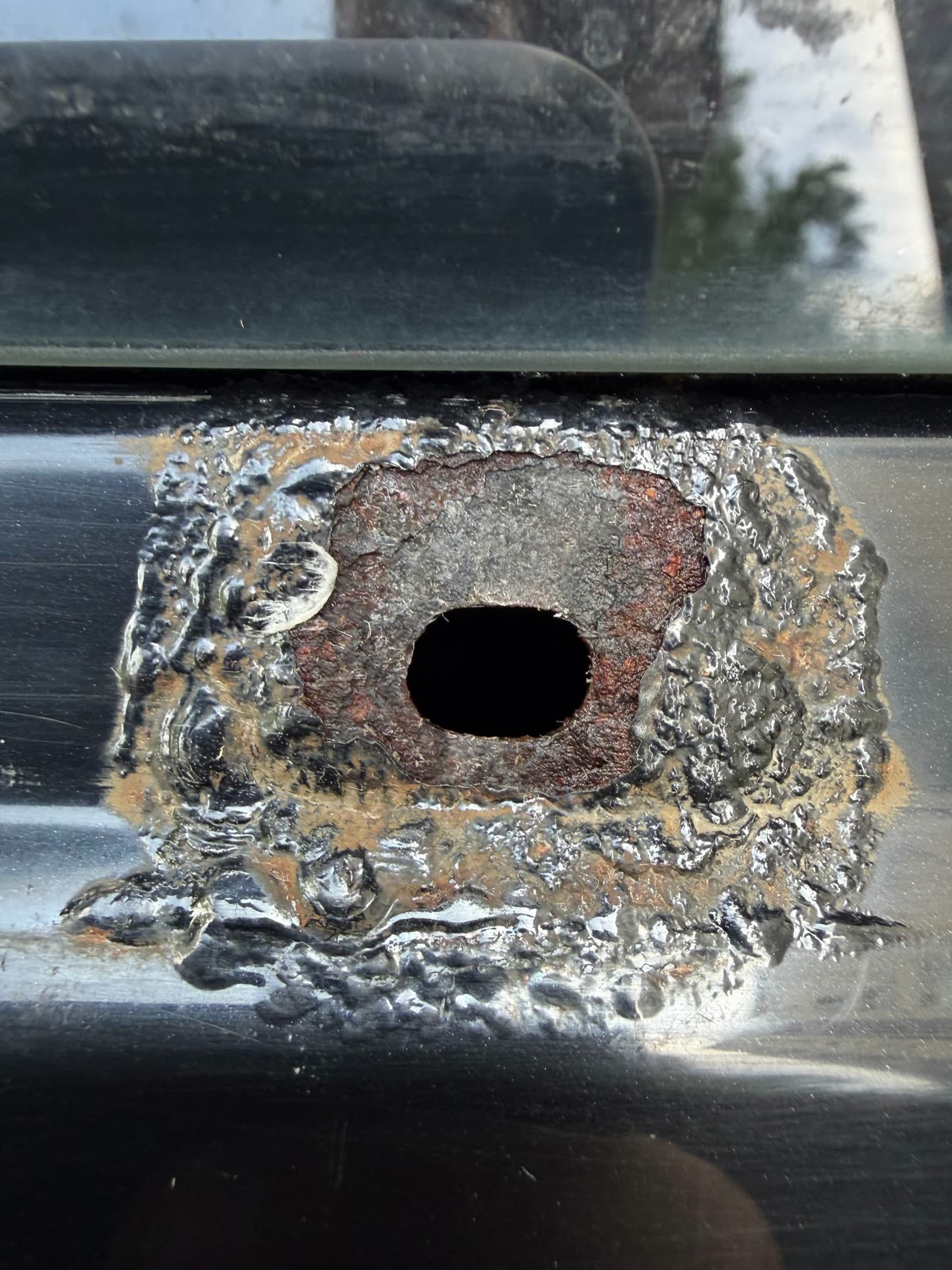 Rear chrome trim after acid-etch primer and top-coat repaint — repaired finish