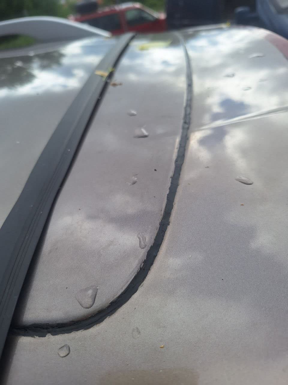 Gap at the upper edge of the trunk lid where waterproofing sealant was applied