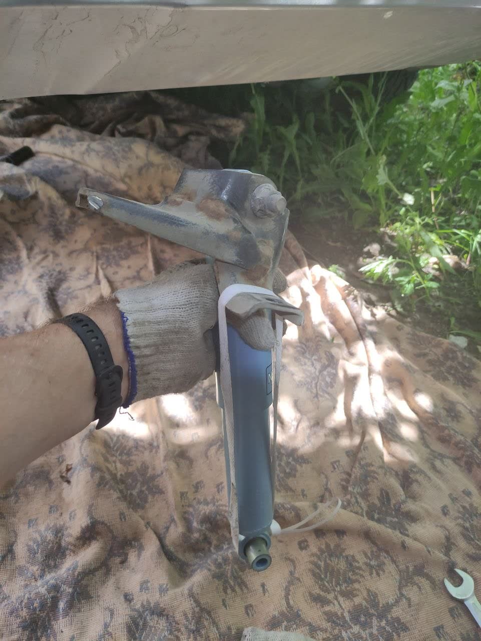 Photo showing the shock absorber compressed and tied with cord before extraction