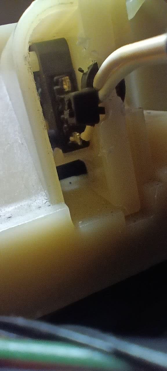 Close-up of the metal piece with integrated retaining clips, accessible after removing the shift-lever surround panel