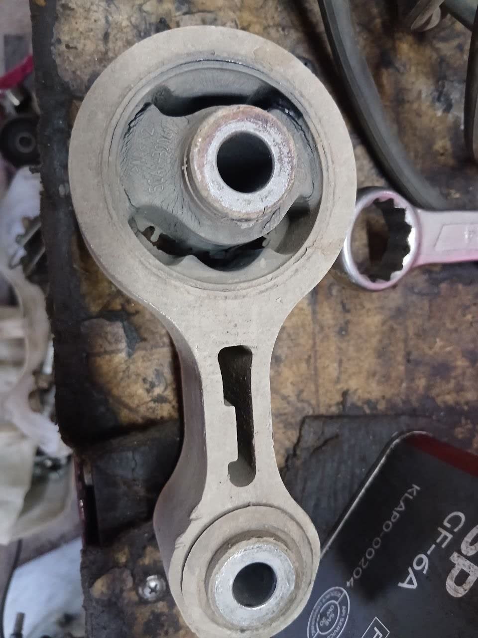 Photo of the deteriorated rear engine mount showing cracked rubber and visible wear