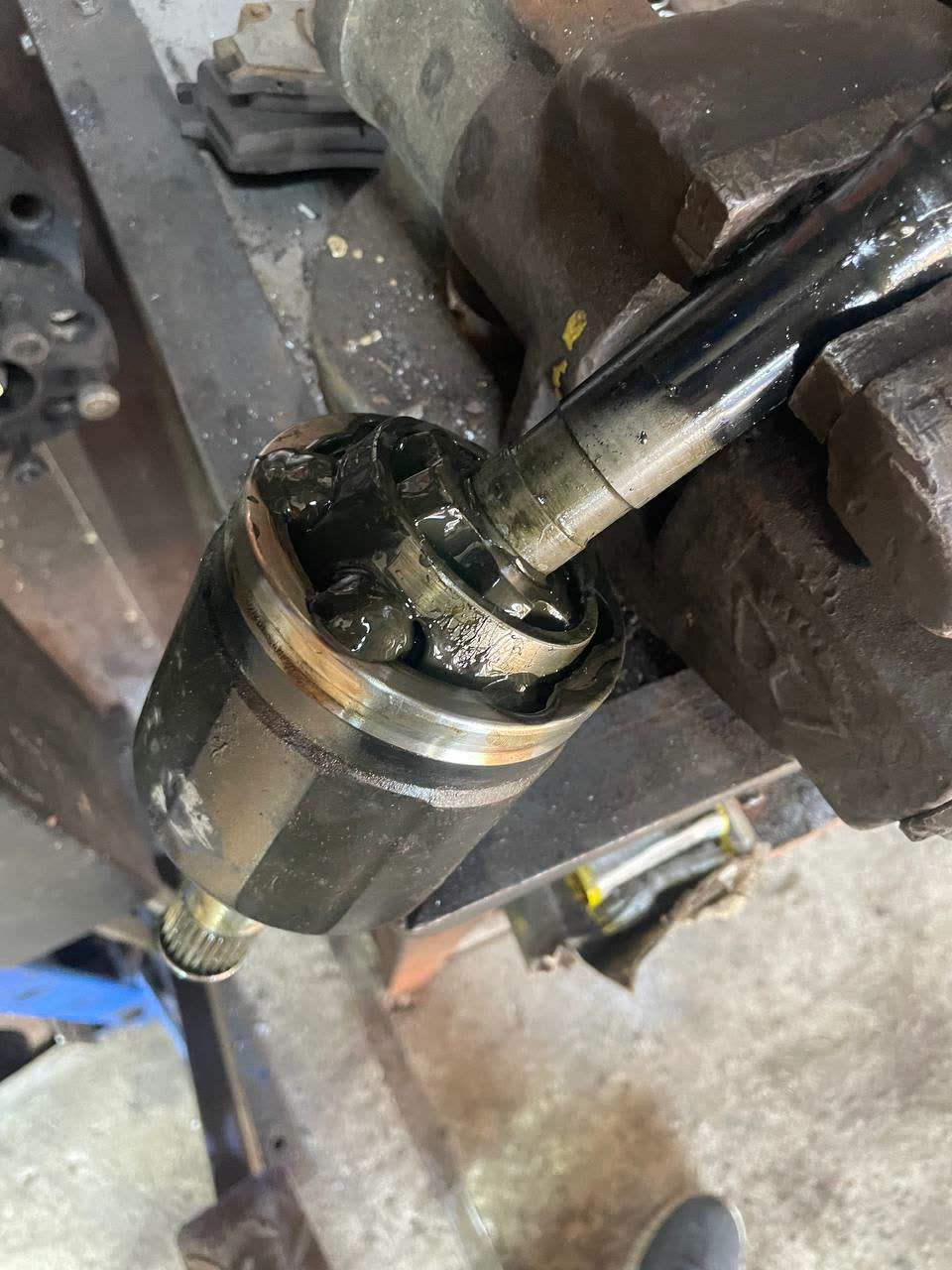 Ball-type inner CV joint component from a manual-transmission drive, shown by the mechanic instead of the expected tripoid type