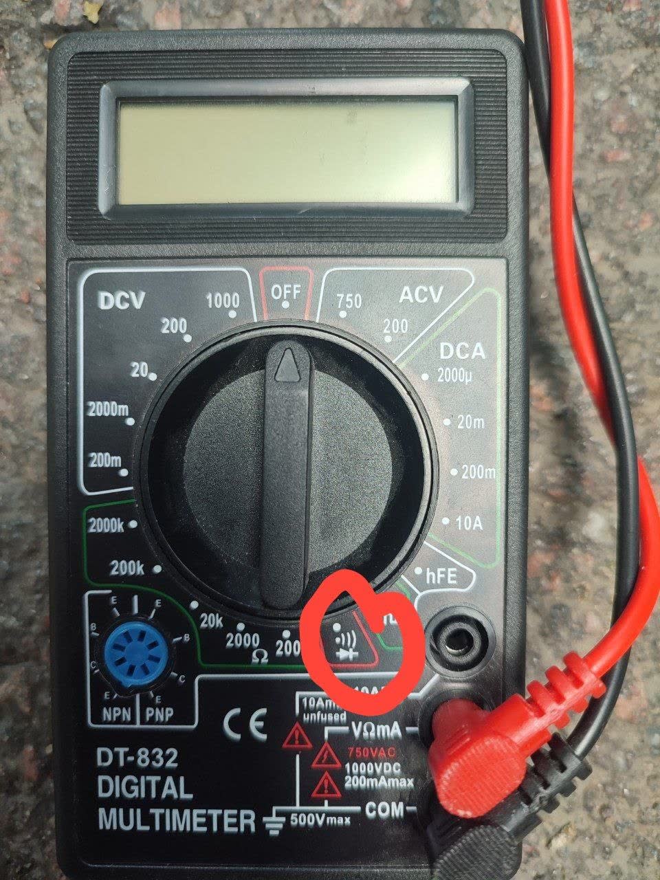 A DT-832 digital multimeter with the diode/continuity-test position circled in red, marking the setting recommended for checking the suspect circuit