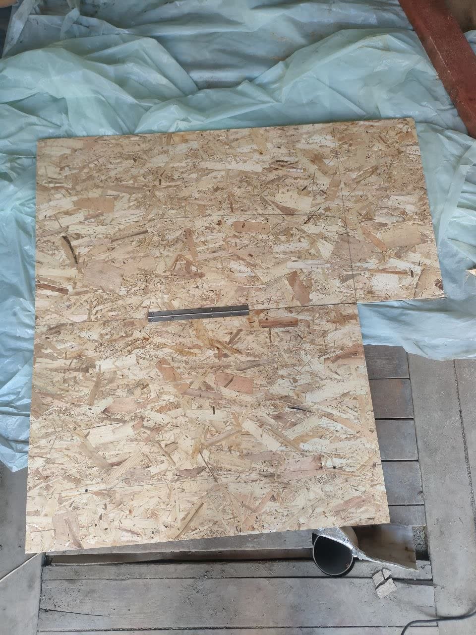 Photo of the OSB-3 cargo floor installed with the hinged access panel over the spare wheel