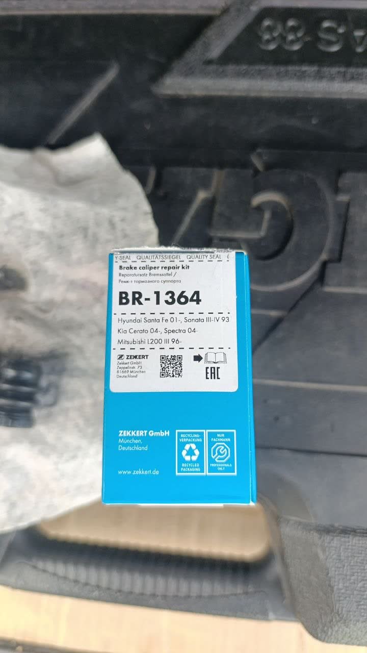 Photo of the Zekkert BR-1364 brake caliper repair kit box, listing catalog fitment for Hyundai Santa Fe (2001+), Hyundai Sonata III-IV (1993+), Kia Cerato (2004+), Kia Spectra (2004+), and Mitsubishi L200 III (1996+) — none of which are FAW/Mazda models, showing the cross-fit source is not obvious from the box alone