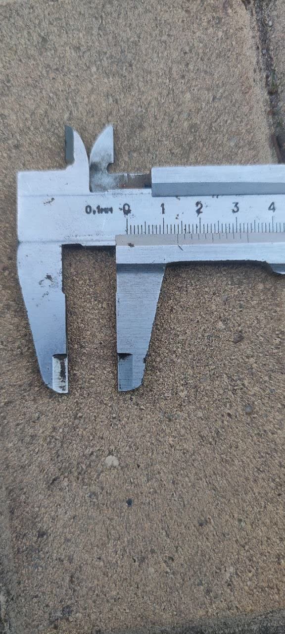 Vernier calipers measuring the spring wire; the reading is about 13.5 mm