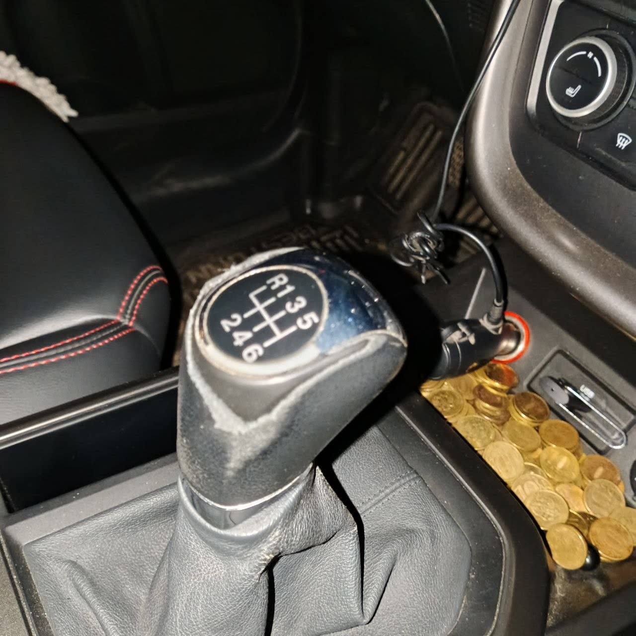Gear knob whose cover is peeled almost entirely, exposing the base underneath