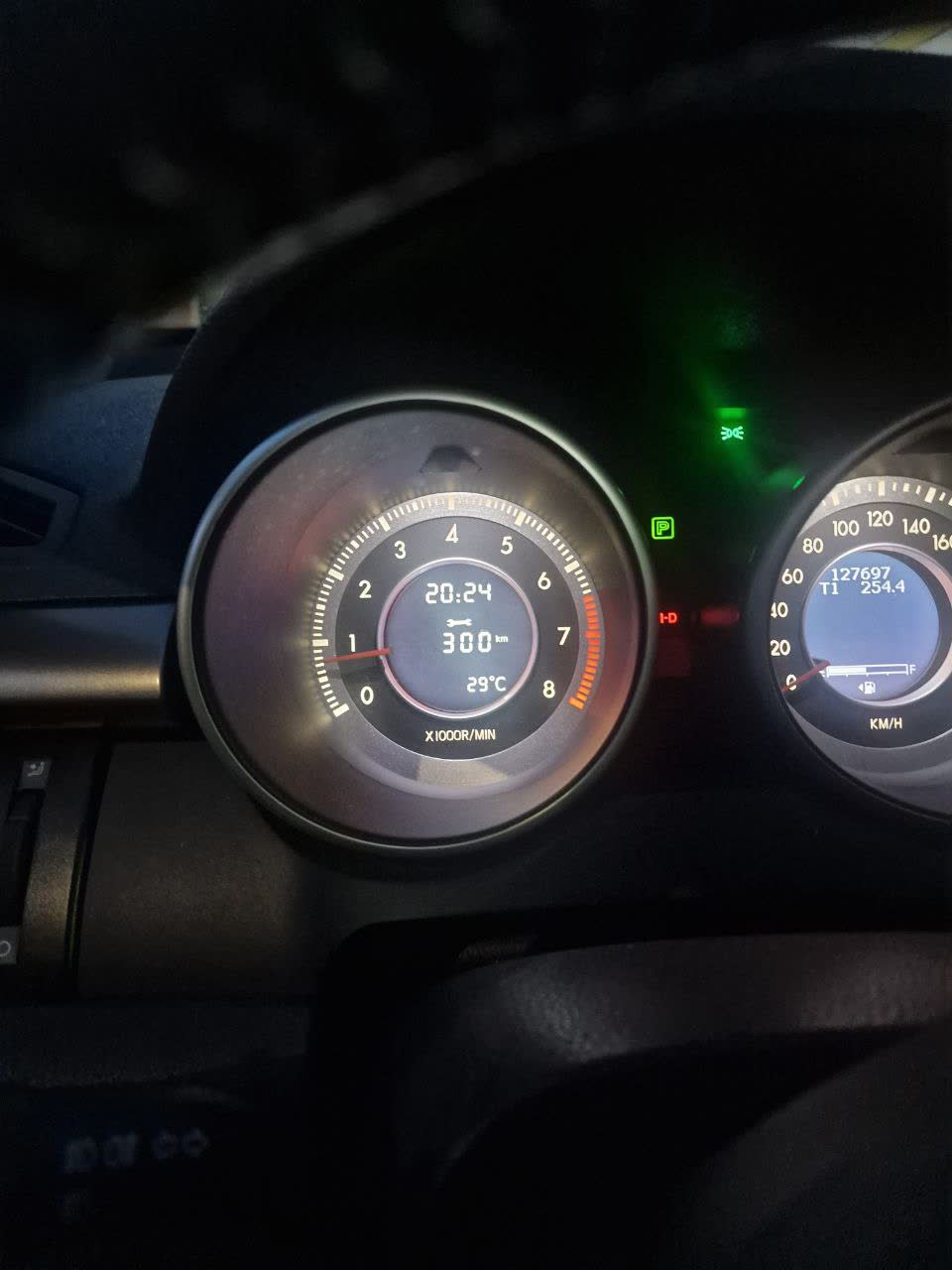 Dashboard photo showing service counter reading "300km" in the center display with temperature 29°C
