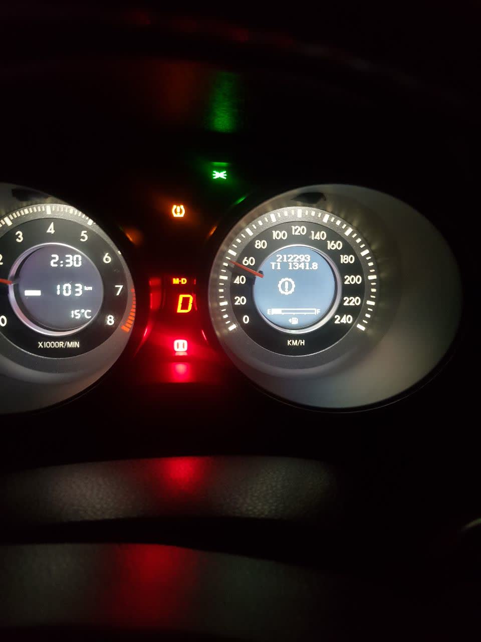 Dashboard photo showing the transmission warning light (yellow gear symbol with exclamation mark) alongside other dashboard indicators, illustrating typical pressure/error light patterns